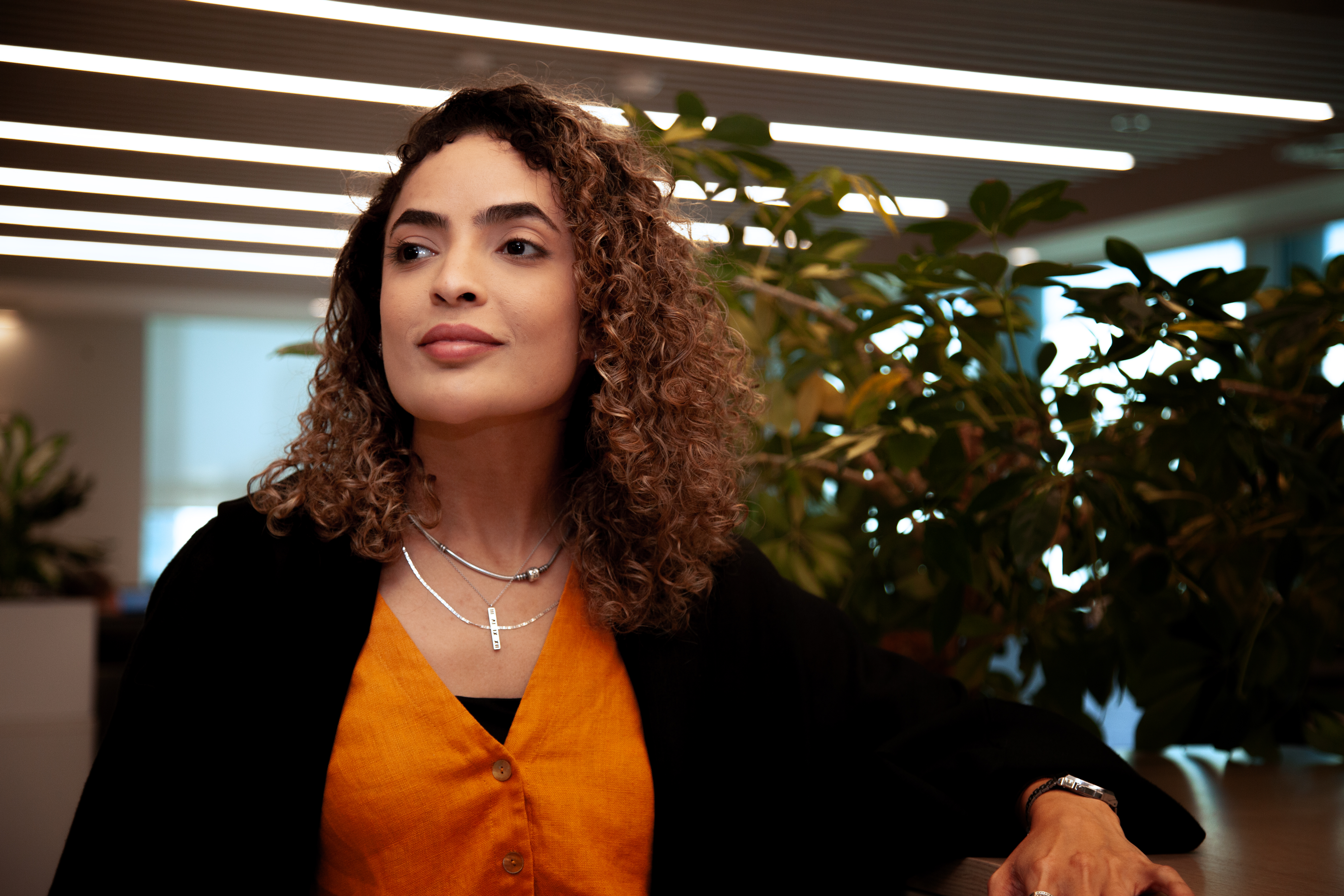 a woman with curly hair and a necklace