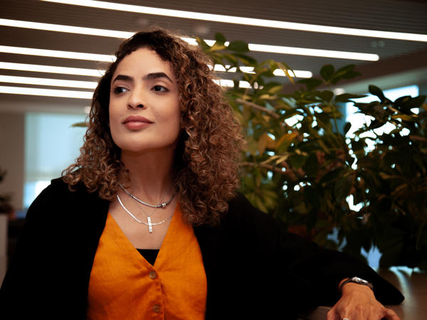 a woman with curly hair and a necklace