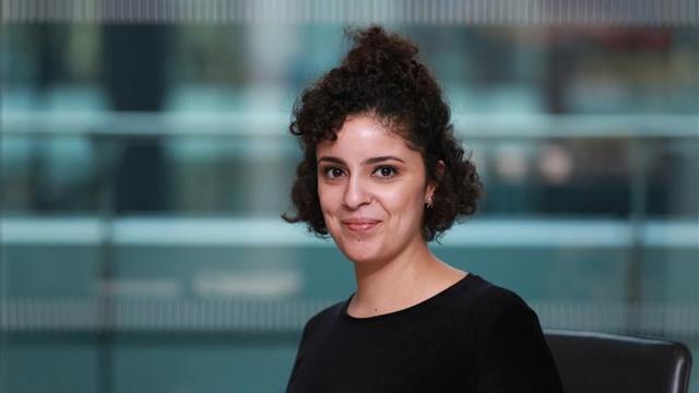 a woman with curly hair wearing a black shirt