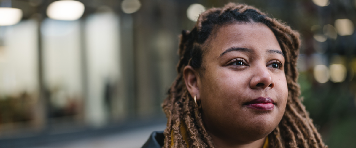 a woman with dreadlocks looking to the side