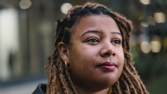 a woman with dreadlocks looking to the side