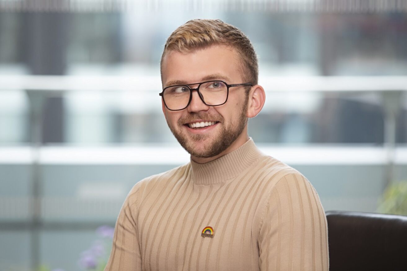 un homme portant des lunettes et un pull à col roulé