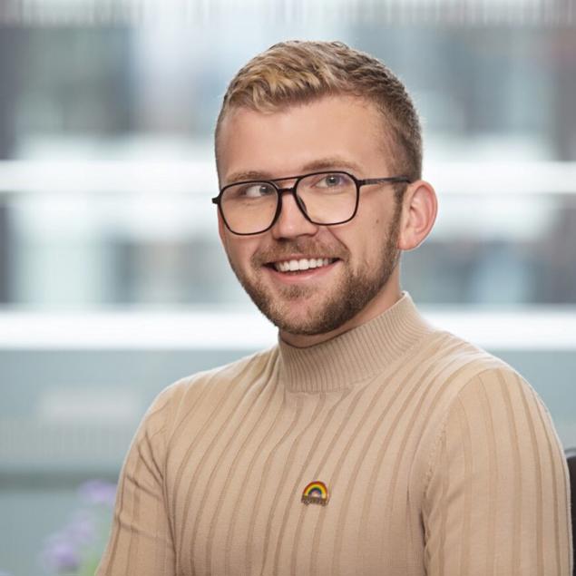 un homme portant des lunettes et un pull à col roulé