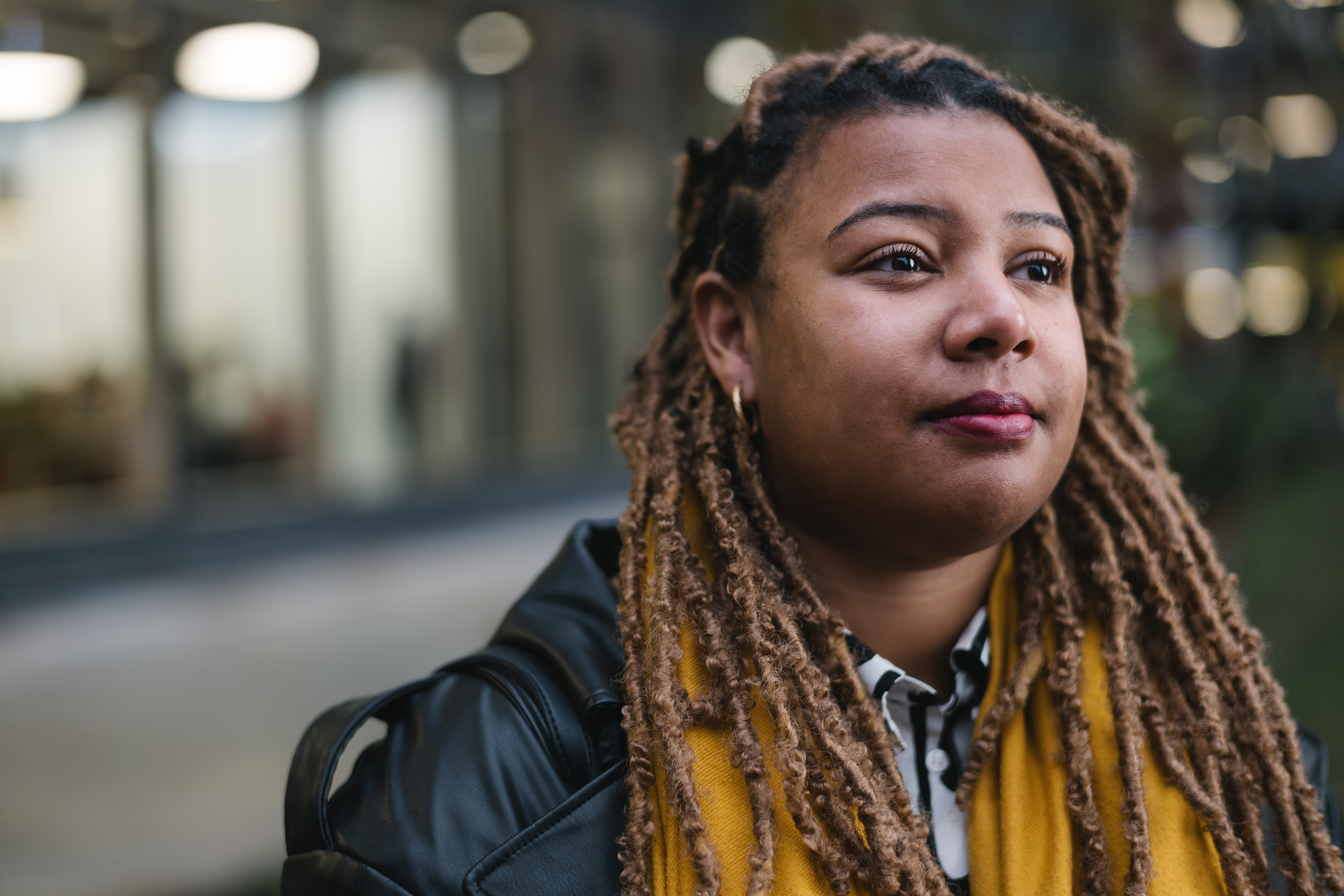 a woman with dreadlocks wearing a yellow scarf