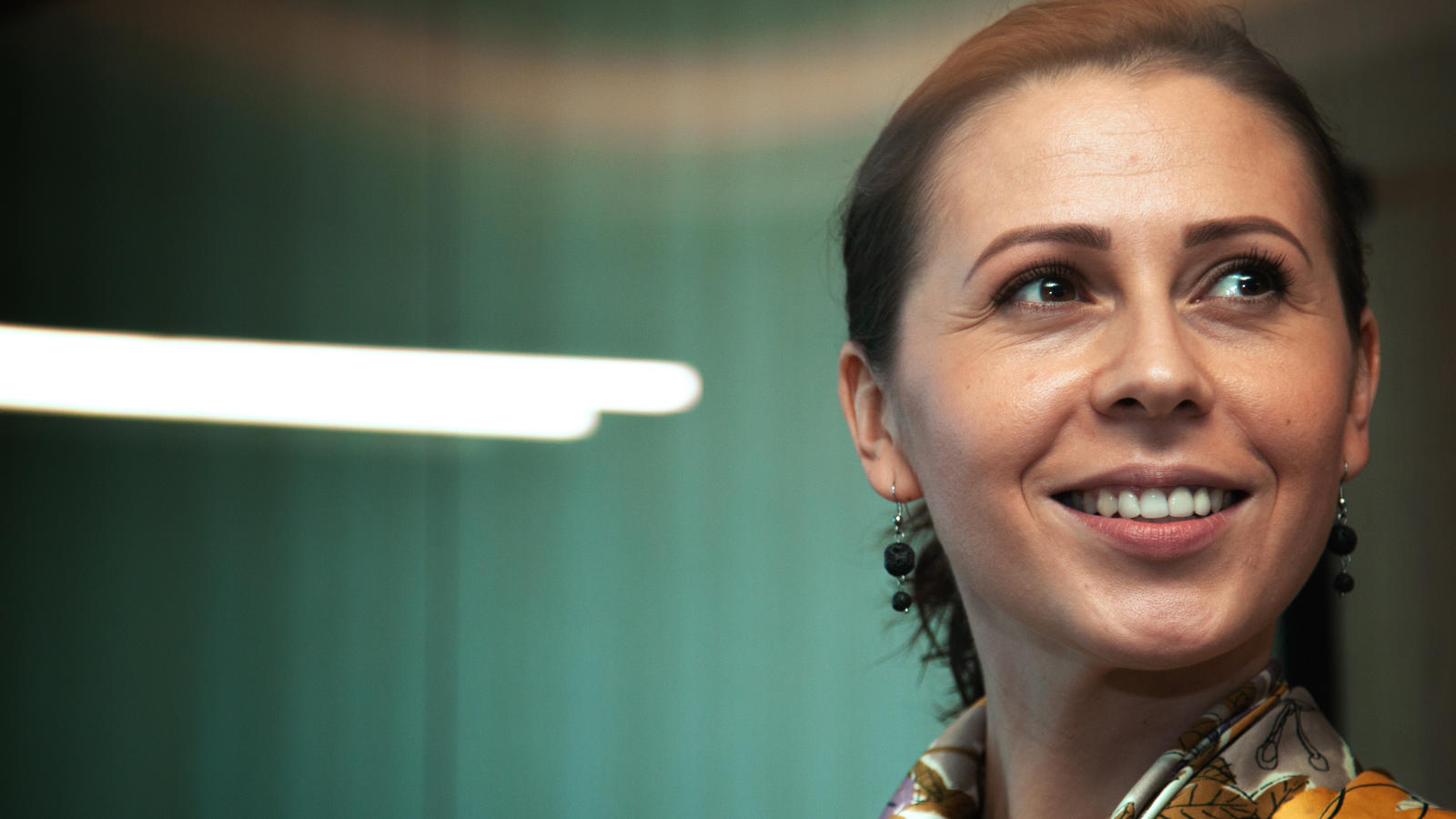 a woman smiling with a scarf around her neck