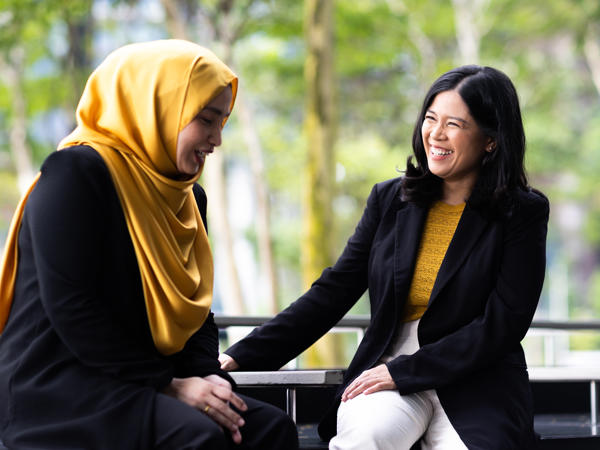 two women sitting on a bench