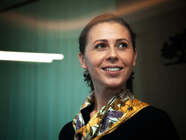 a woman smiling with a scarf around her neck