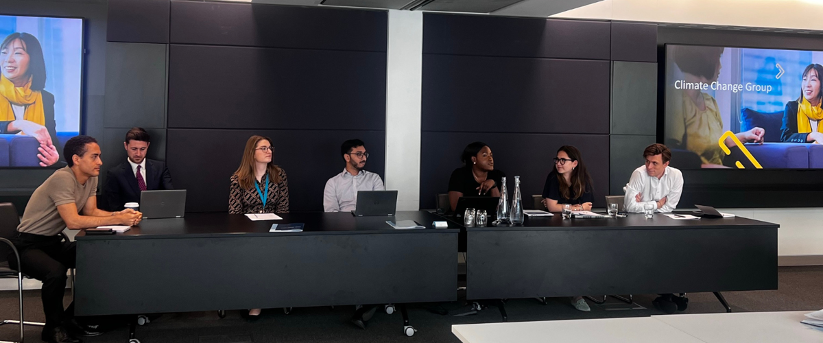 a group of people sitting at tables with laptops