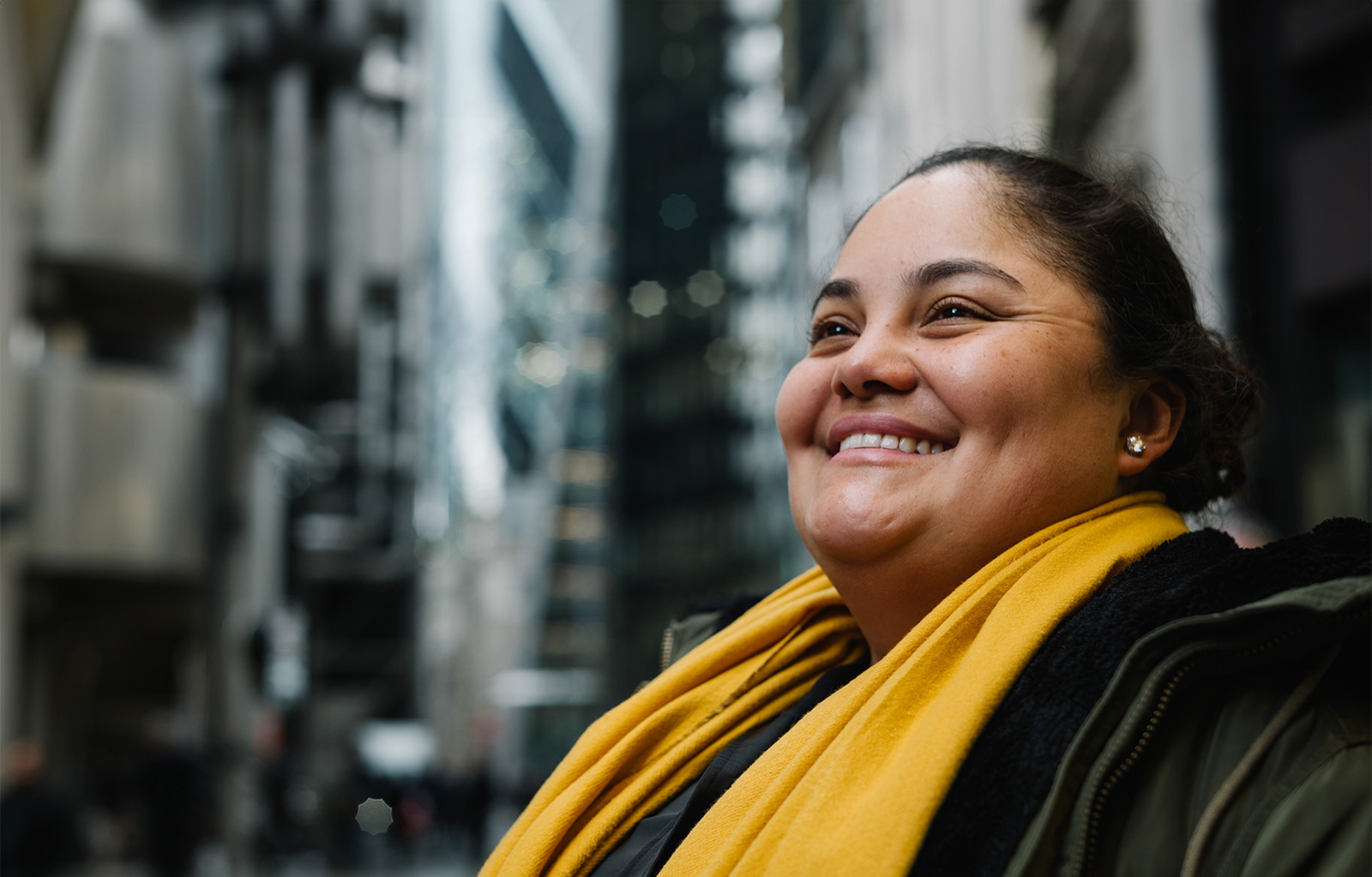 a woman smiling with a yellow scarf