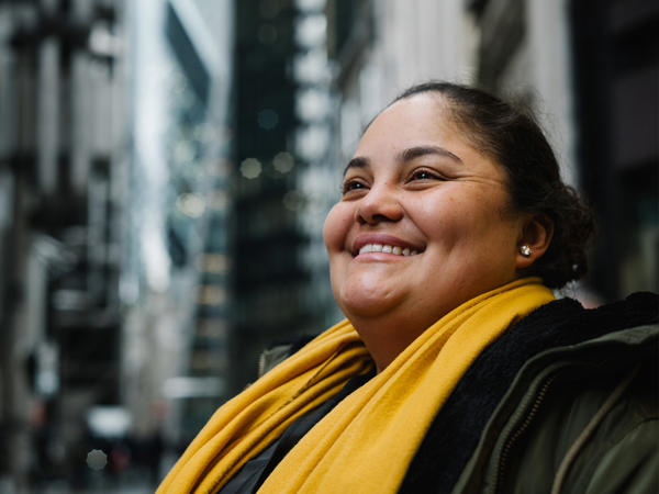 a woman smiling with a yellow scarf