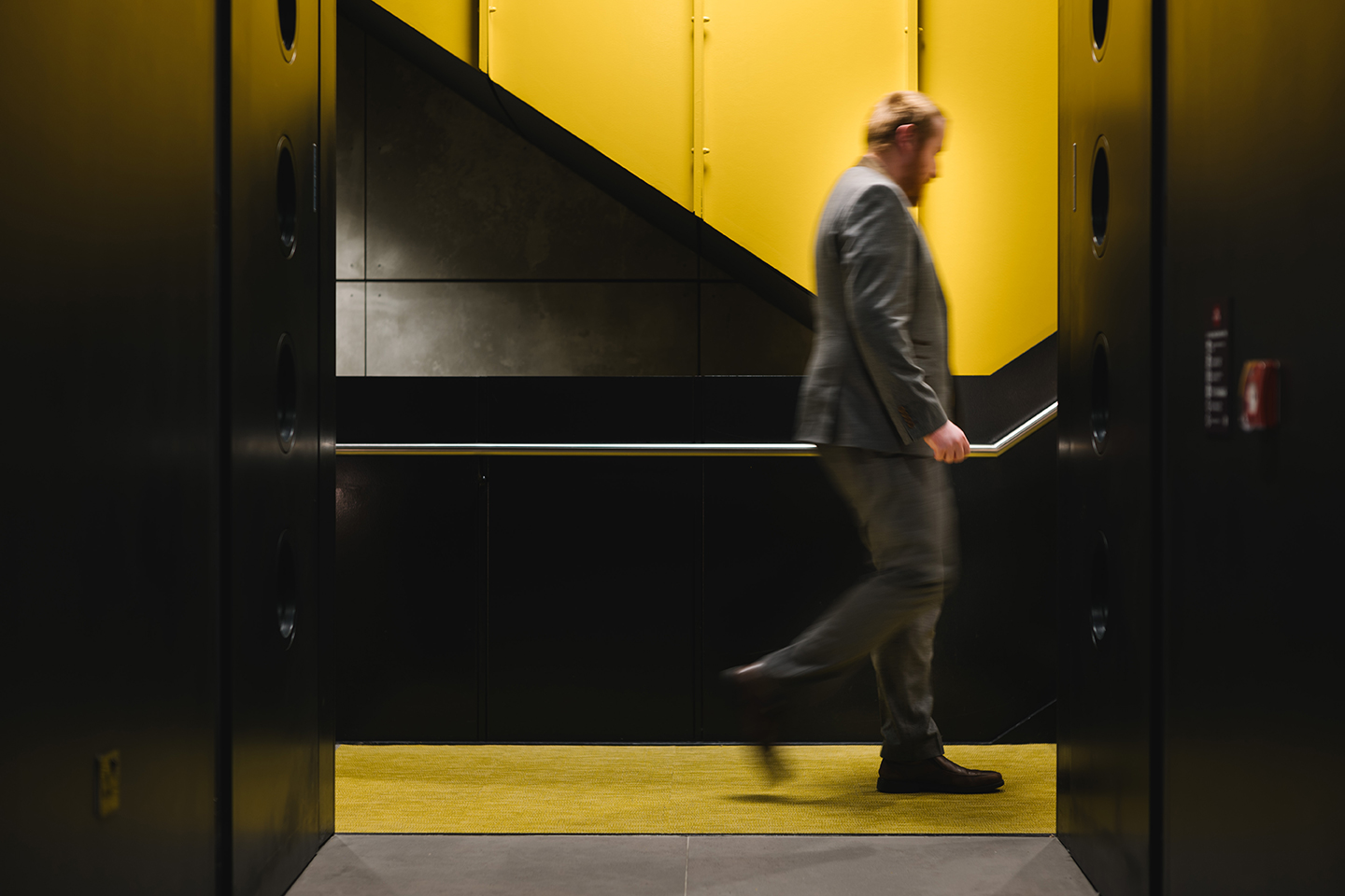 a man walking up a yellow and black staircase