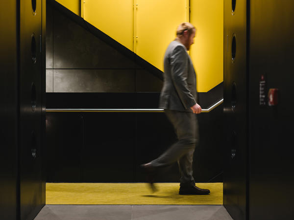a man walking up a yellow and black staircase