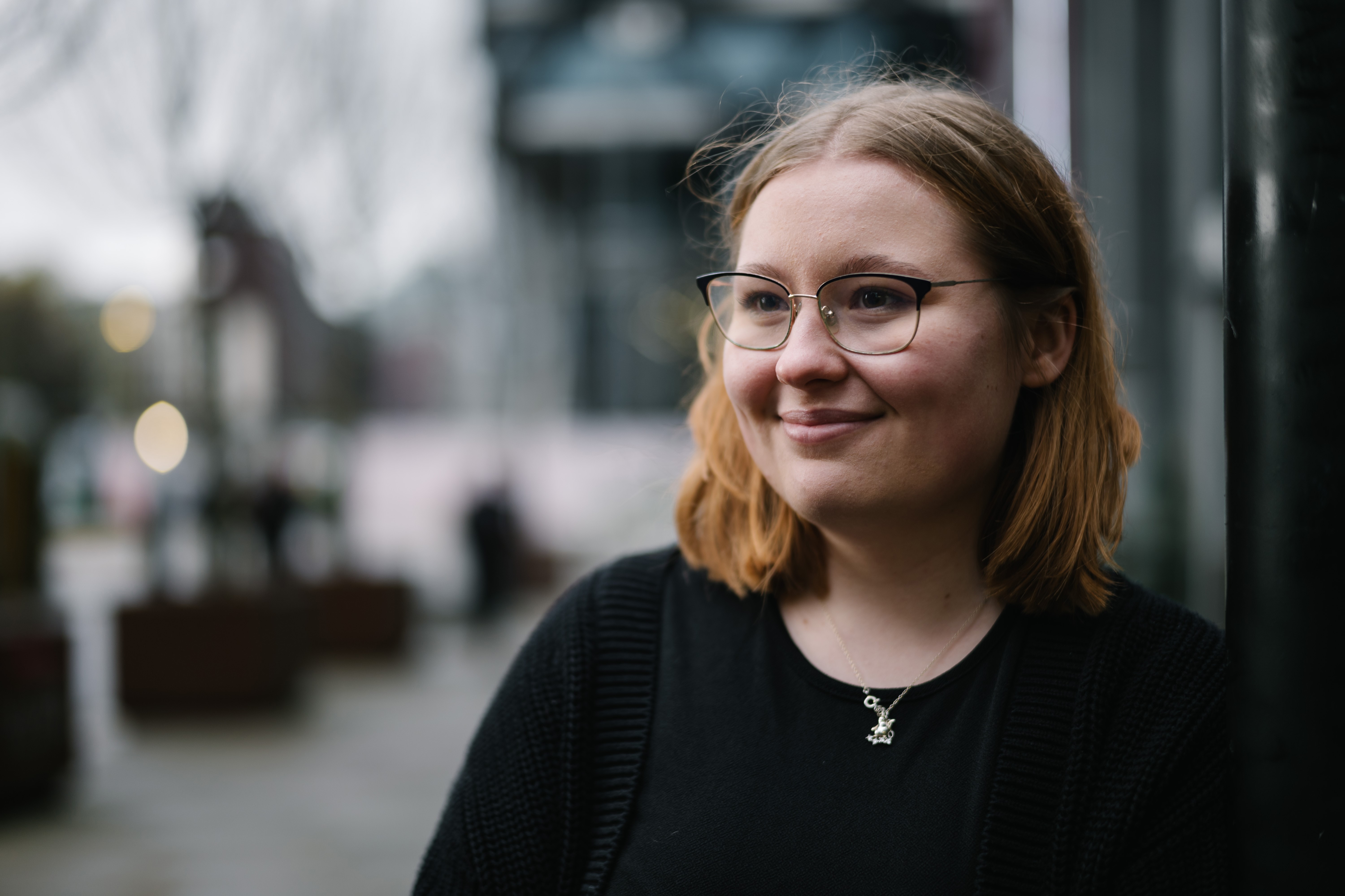 a woman wearing glasses and a black shirt