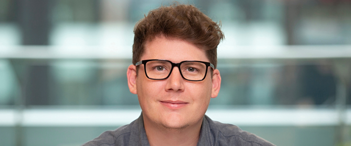 a man wearing glasses and smiling