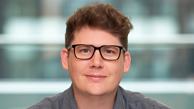 a man wearing glasses and smiling