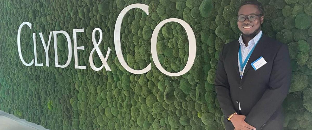 a man standing in front of a wall of moss