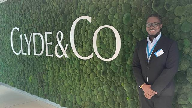 a man standing in front of a wall of moss