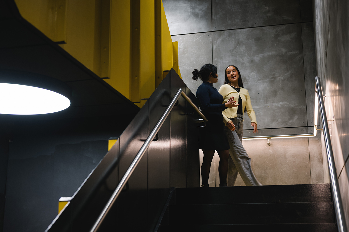 two women talking on a staircase