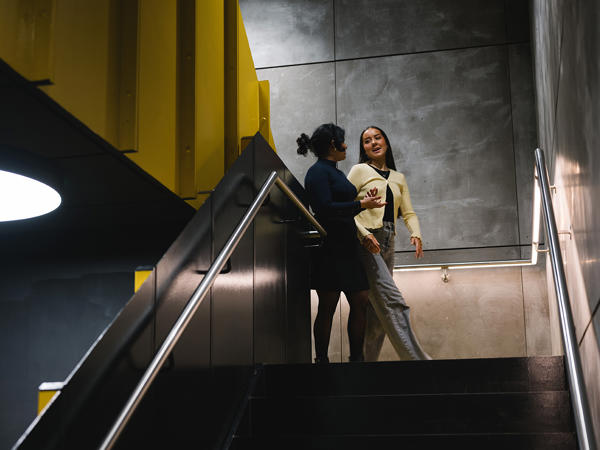 two women talking on a staircase