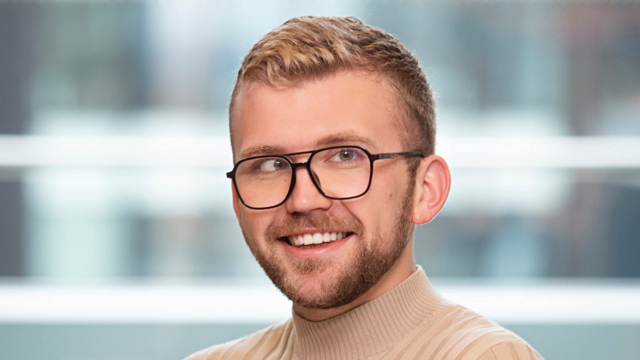 a man wearing glasses and a turtleneck