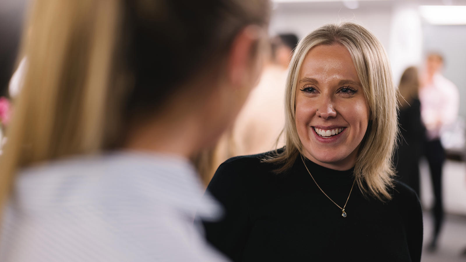 a woman smiling at another woman
