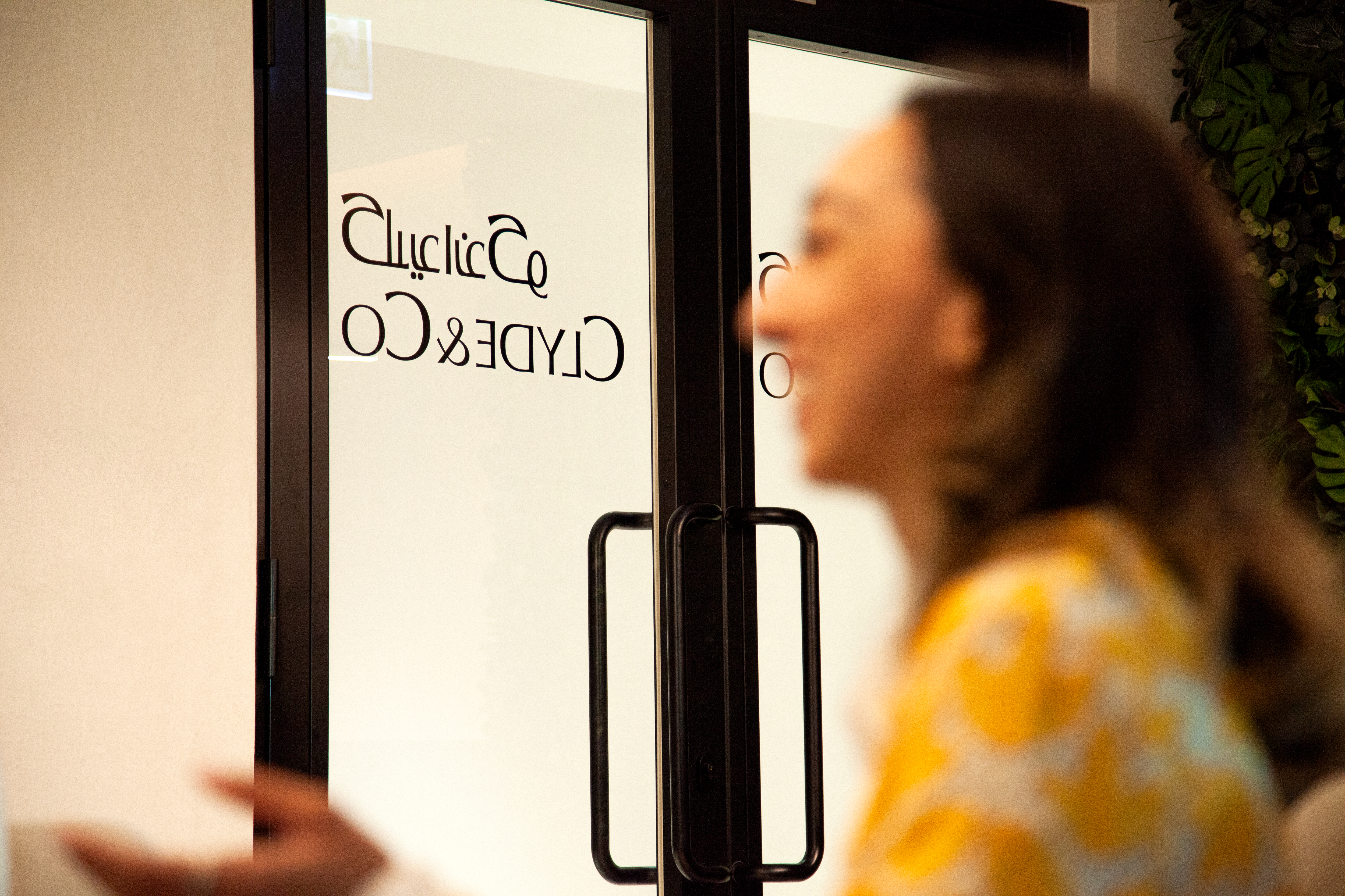 a woman looking at a sign on a door
