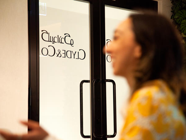 a woman looking at a sign on a door