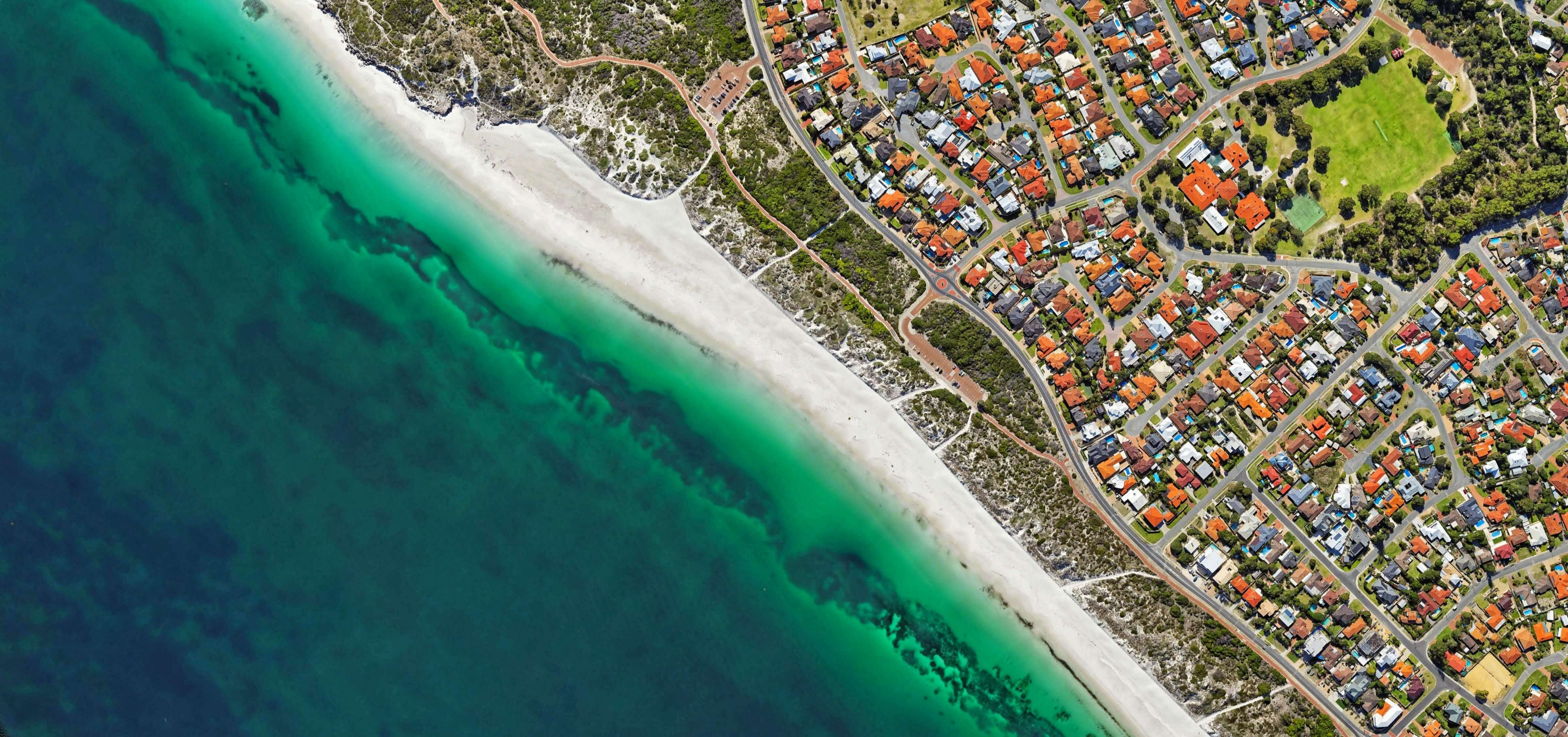 a beach with houses and a body of water
