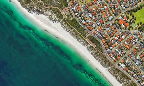 a beach with houses and a body of water