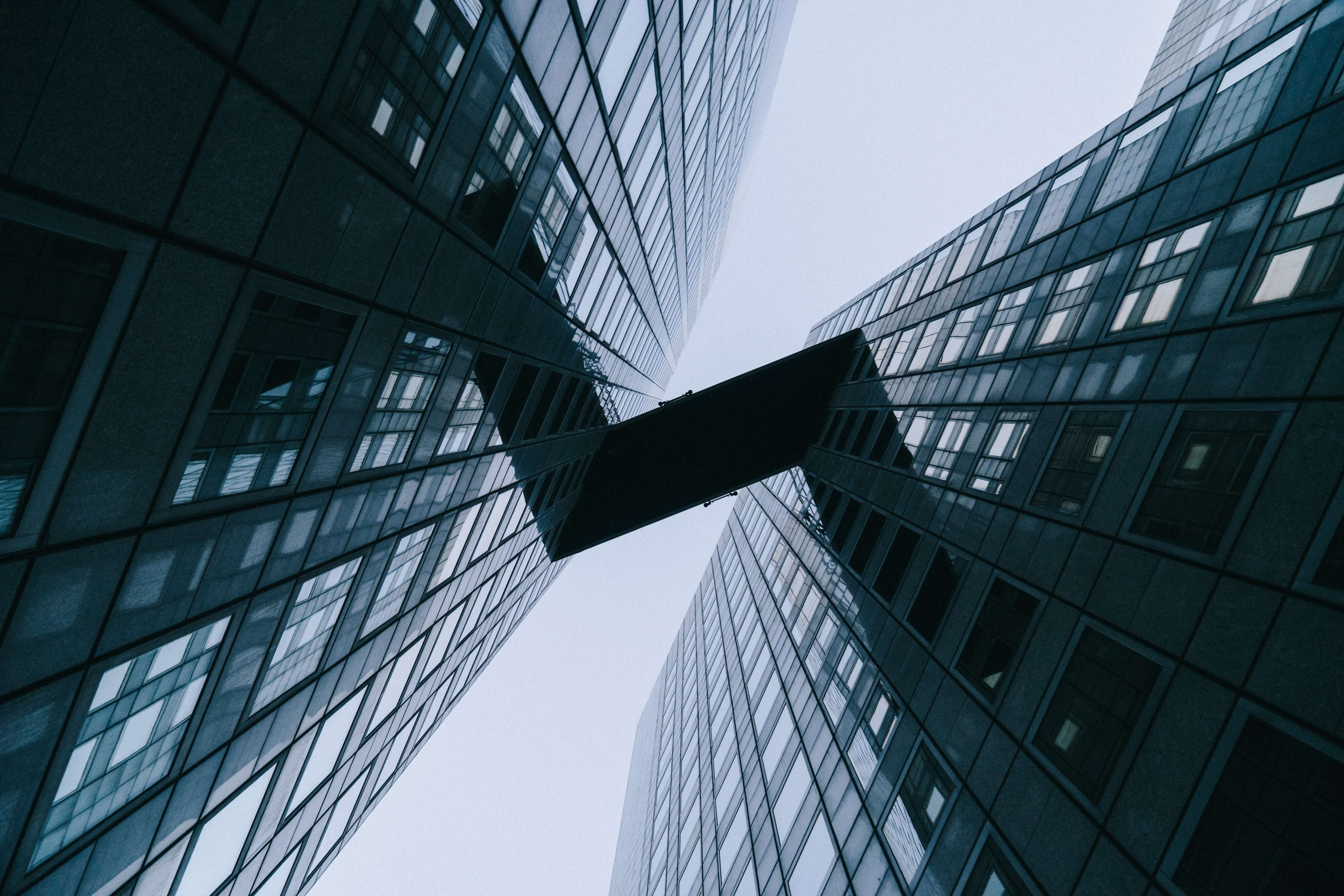 looking up view of a building with a bridge between them