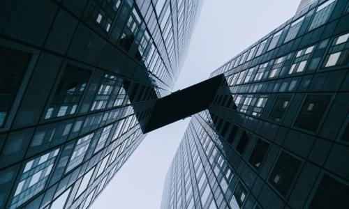 looking up view of a building with a bridge between them