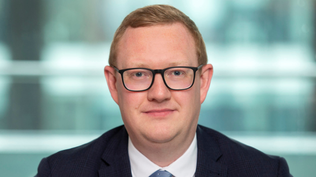 a man wearing glasses and a suit