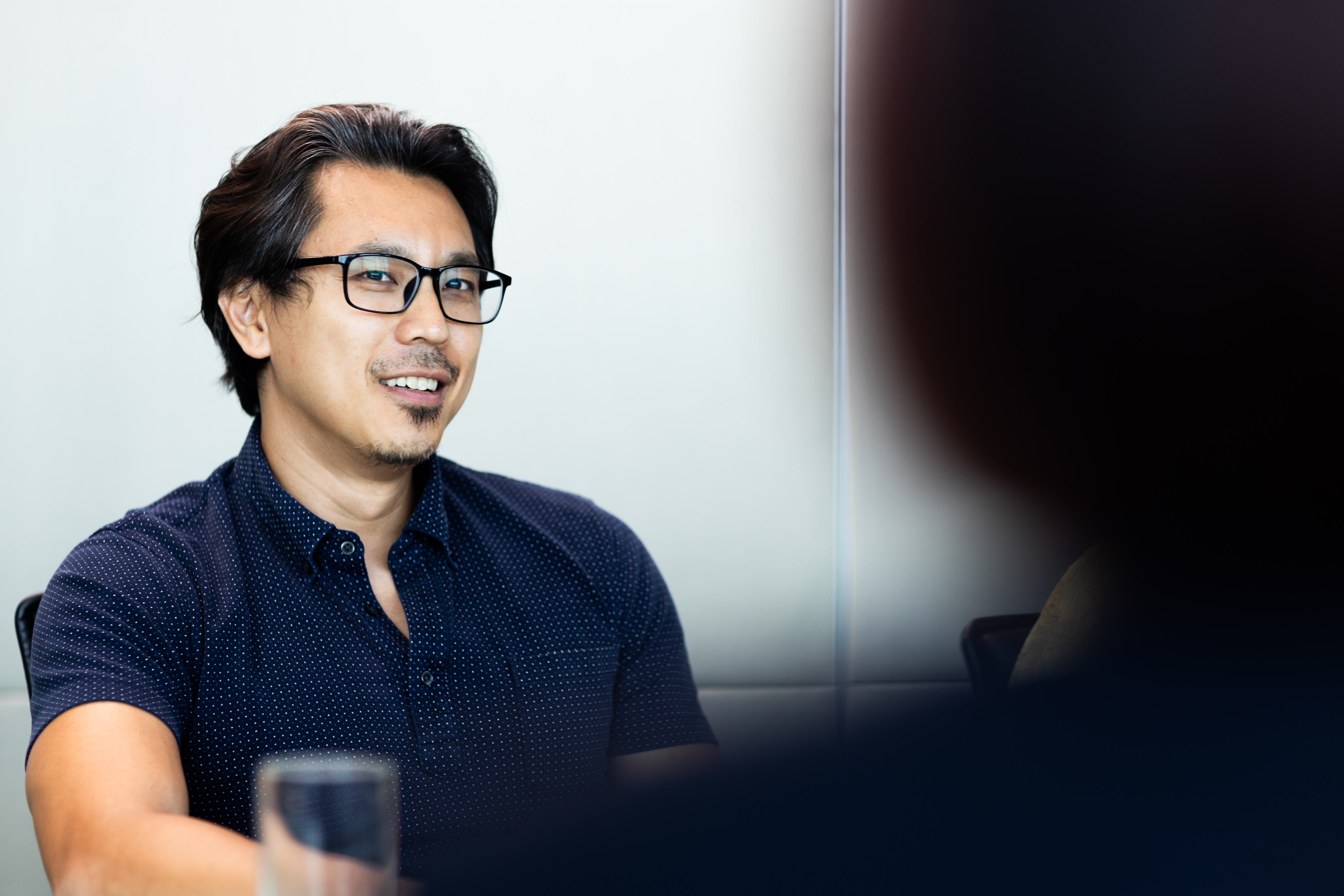 a man in glasses smiling
