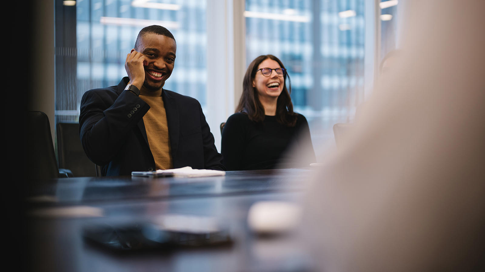 a man and woman laughing at a table