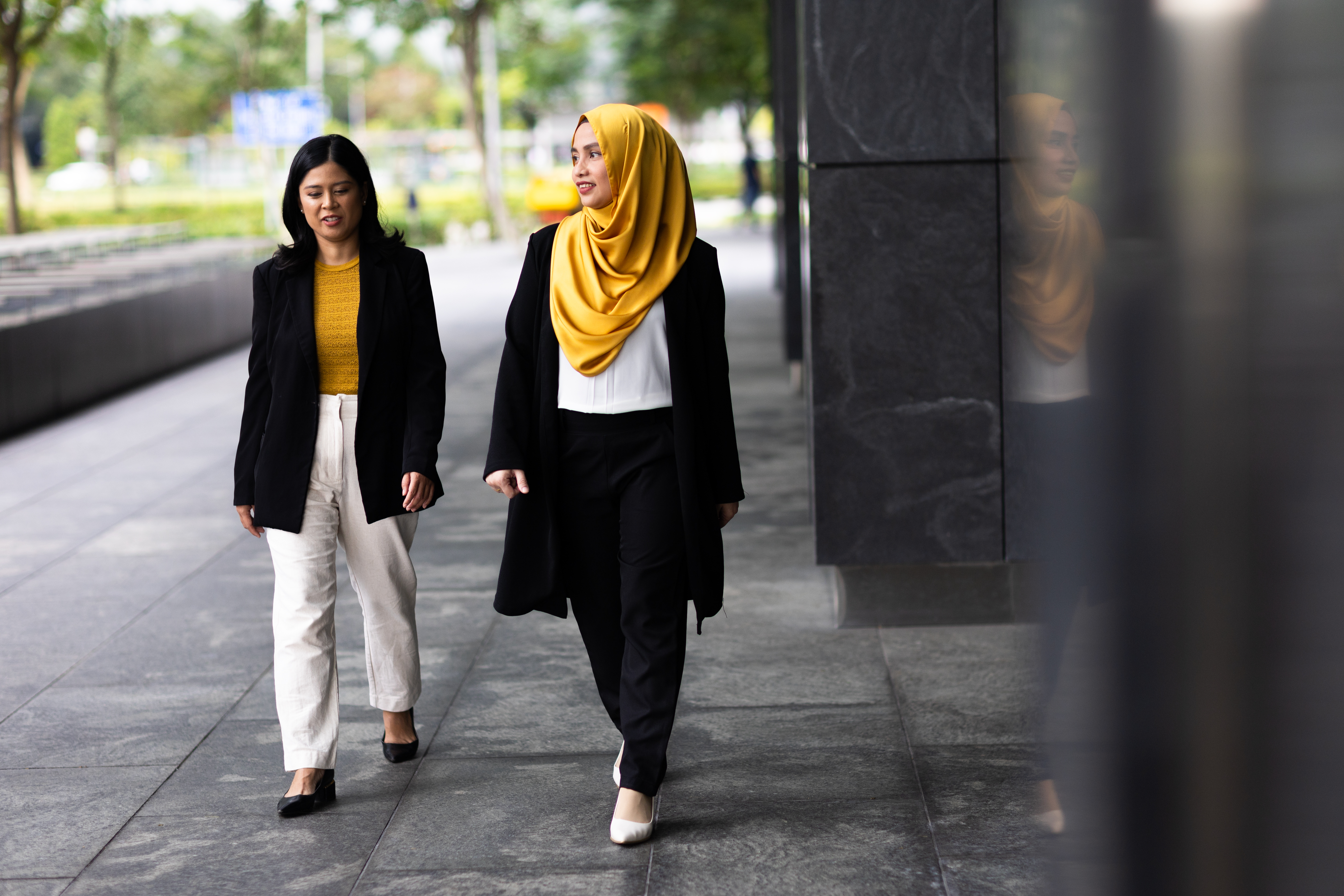 two women walking on a sidewalk