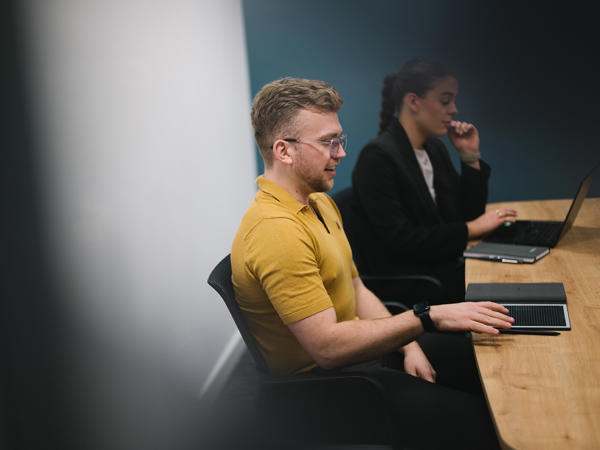 a man and woman sitting at desks with computers