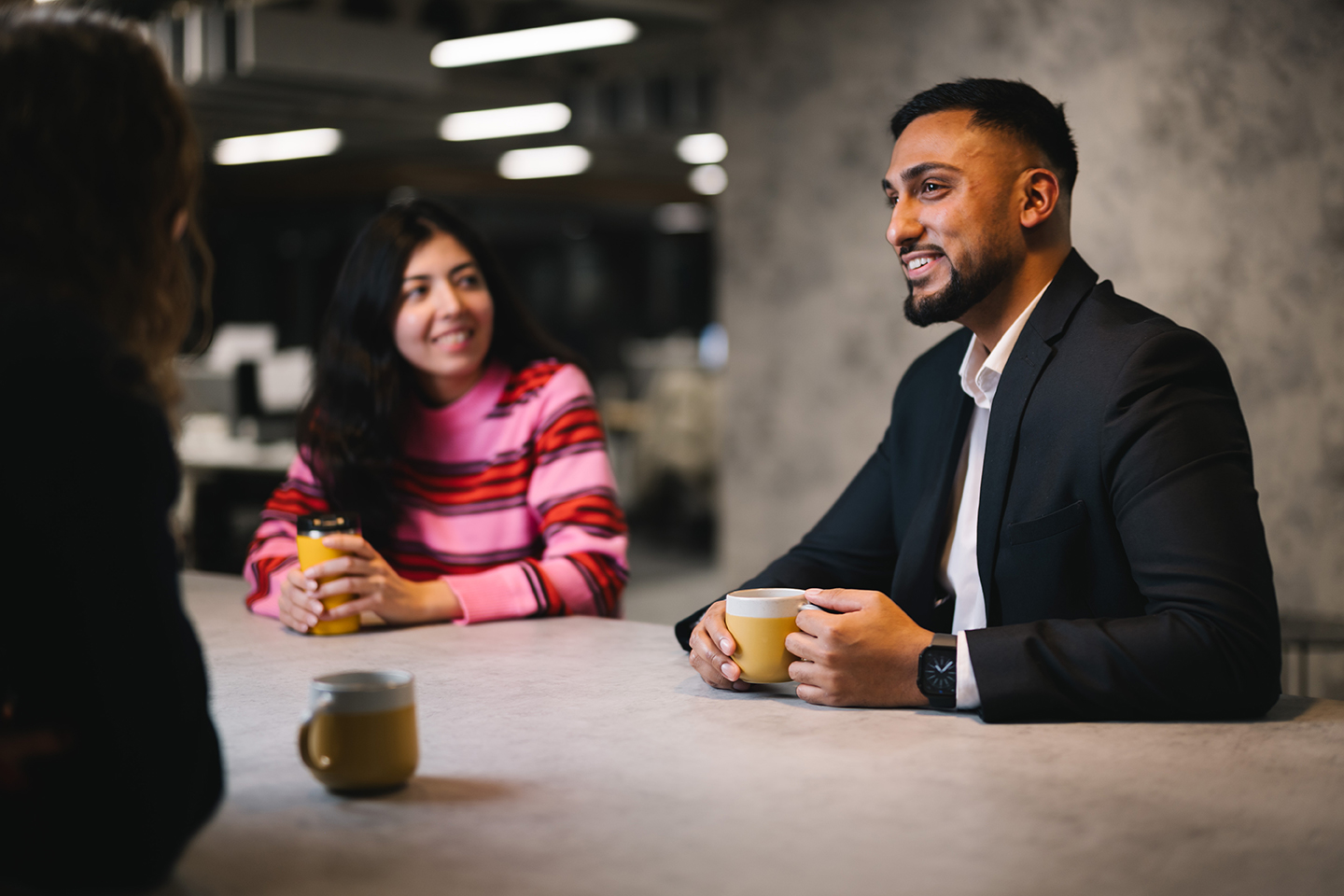 a man and woman sitting at a table with coffee cups
