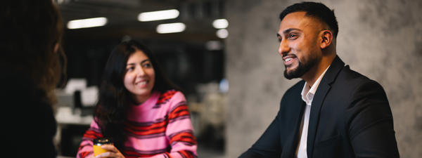 a man and woman sitting at a table with coffee cups