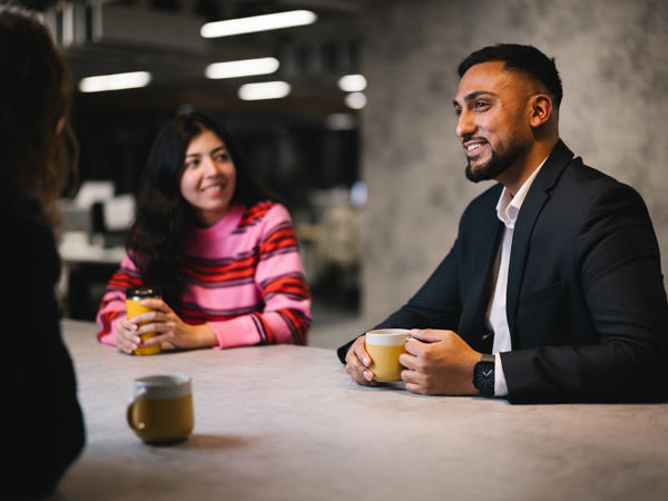 a man and woman sitting at a table with coffee cups
