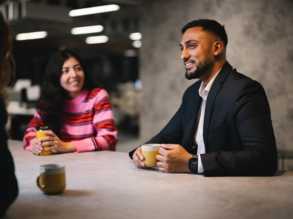 a man and woman sitting at a table with coffee cups