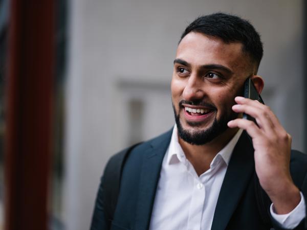 a man in a suit talking on a cell phone