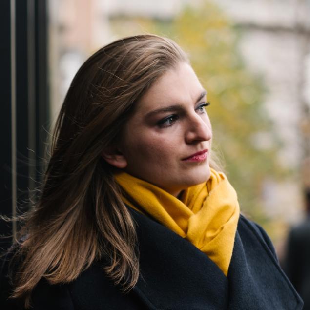 a woman in a black coat and yellow scarf