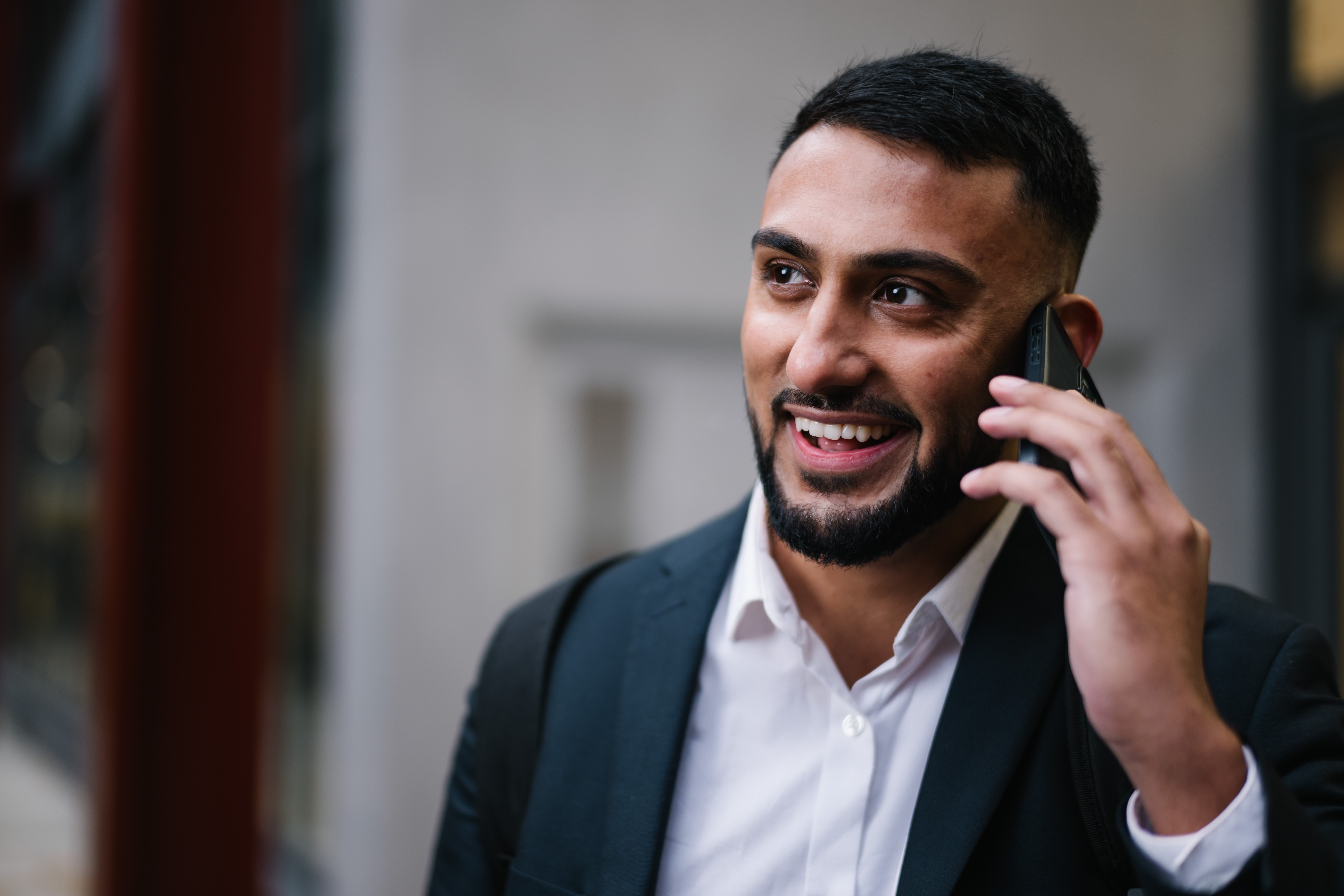 a man in a suit talking on a cell phone