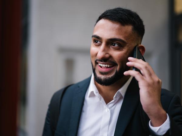 a man in a suit talking on a cell phone
