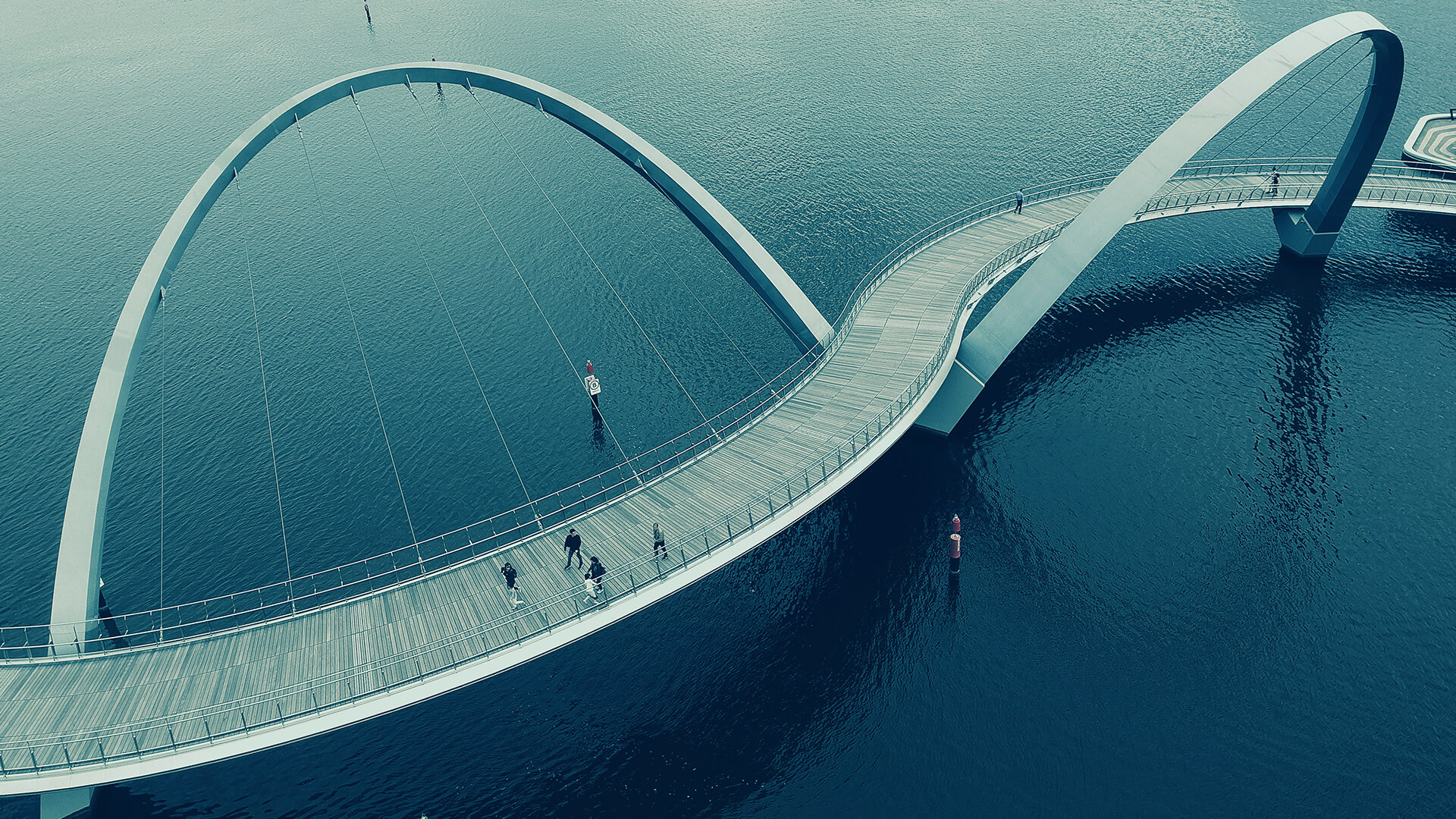 a bridge over water with people walking on it