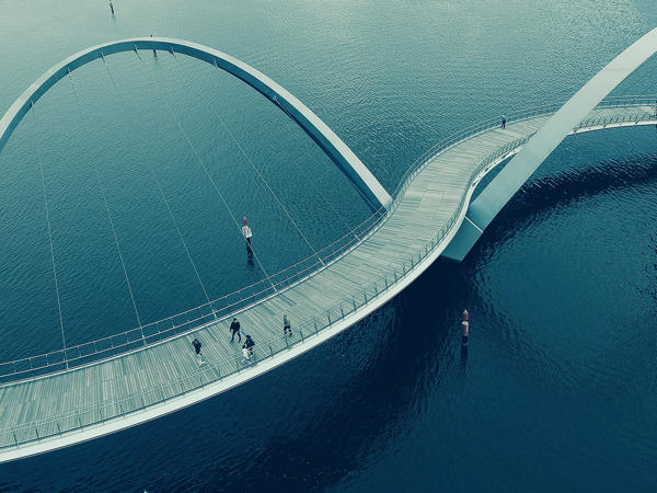 a bridge over water with people walking on it