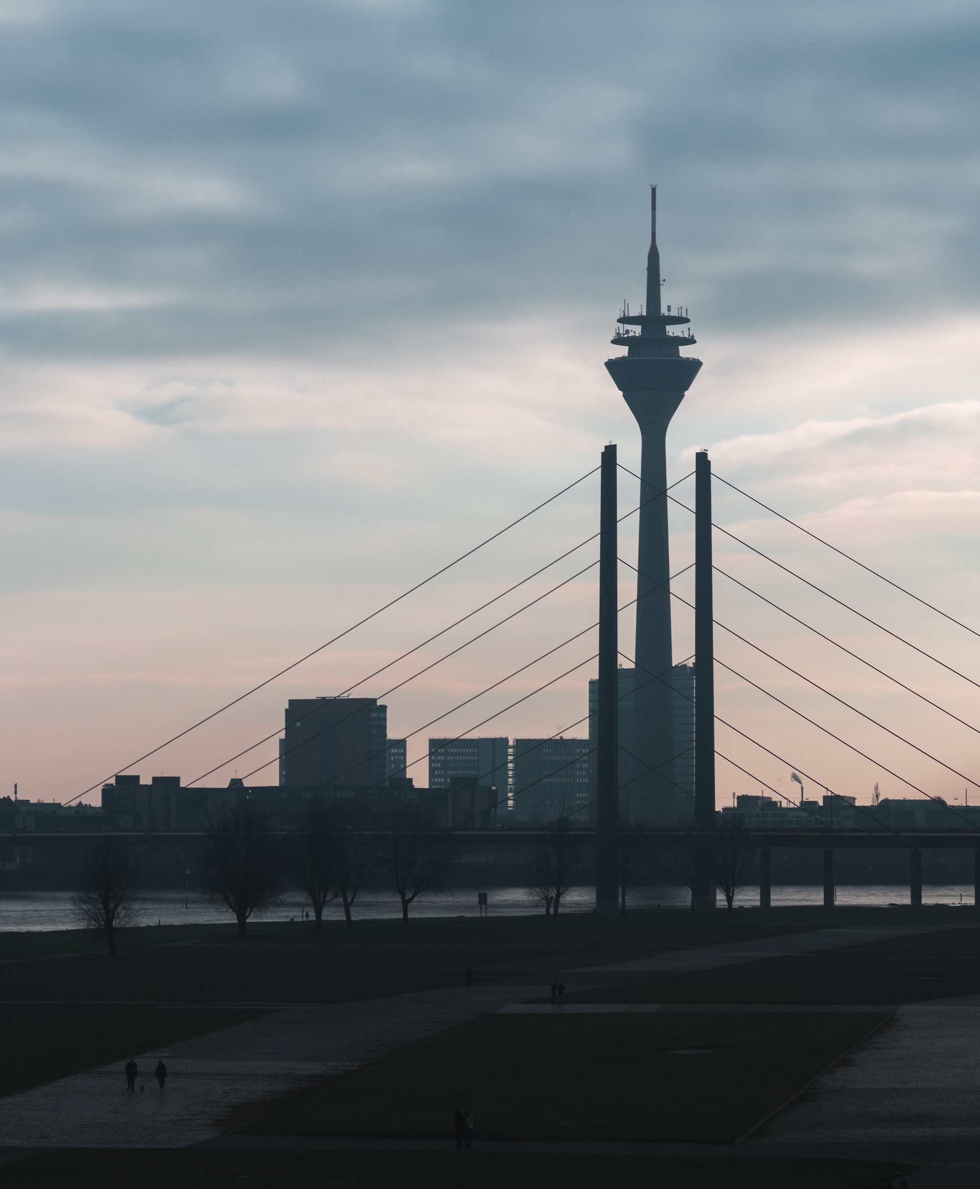 a tall tower with wires and a body of water in the background