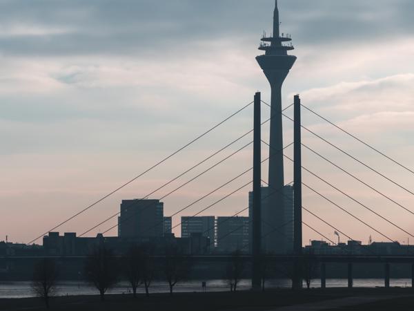 a tall tower with wires and a body of water in the background